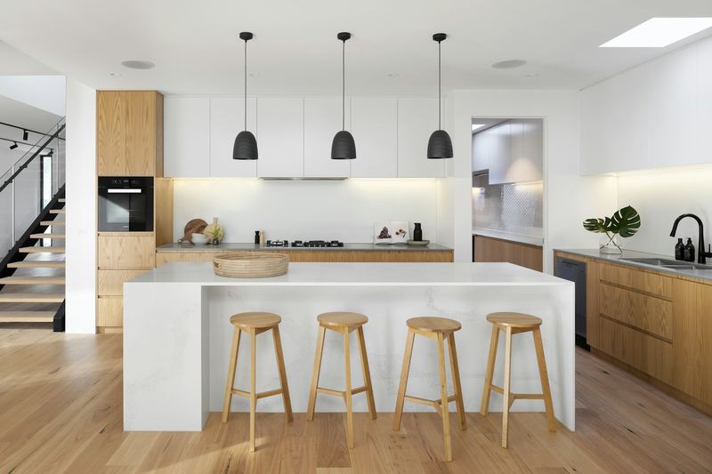 Moderne, helle Küche mit Kochinsel und Holzschränken